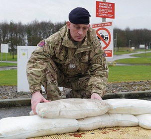 A soldier deploying FloodSax alternative sandbags A soldier deploying FloodSax alternative sandbags
